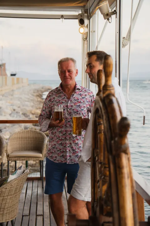 Clientes relajados en la terraza mirando al Mediterráneo