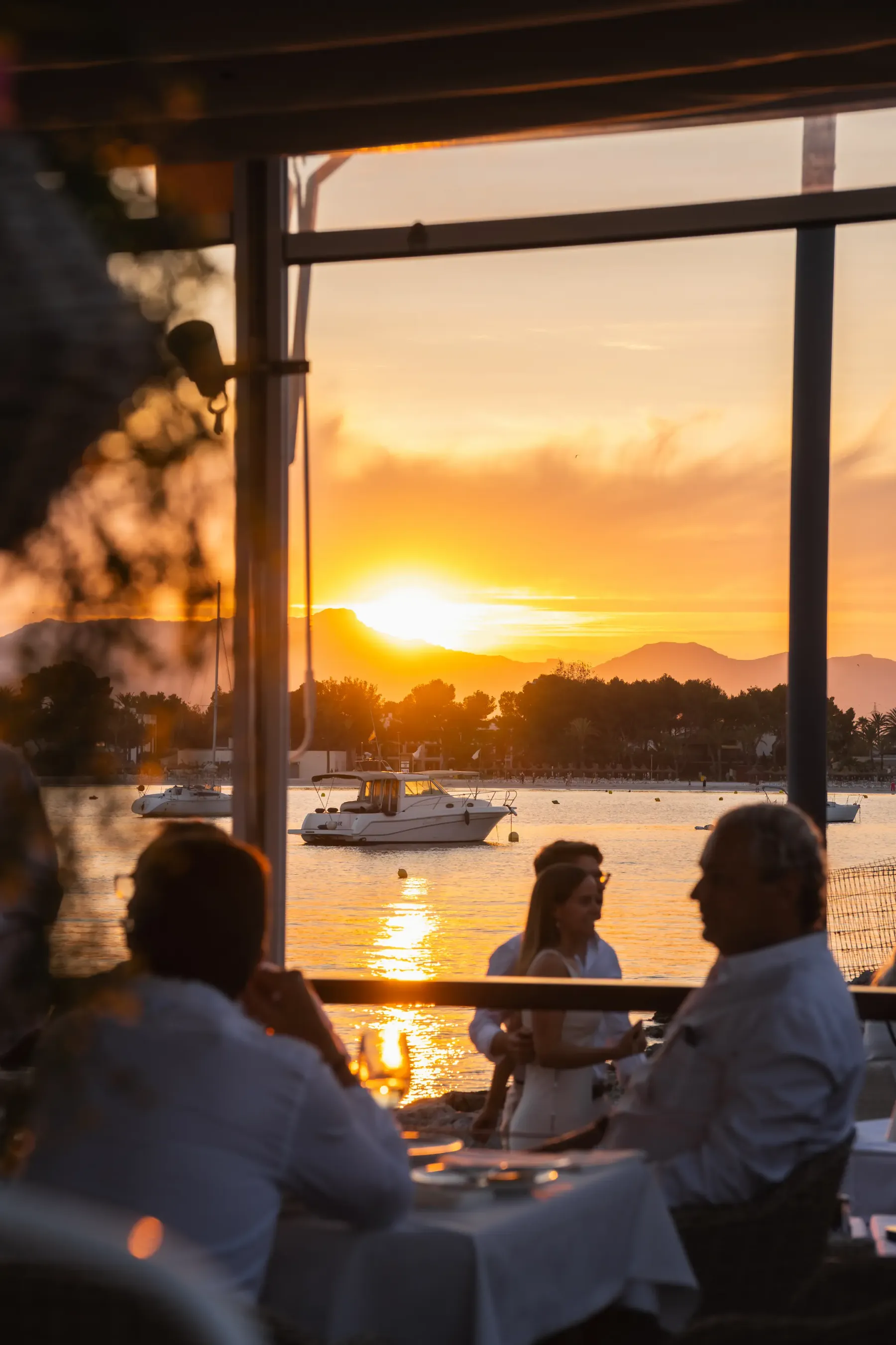 Terraza llena bajo las sombrillas con vistas a la bahía